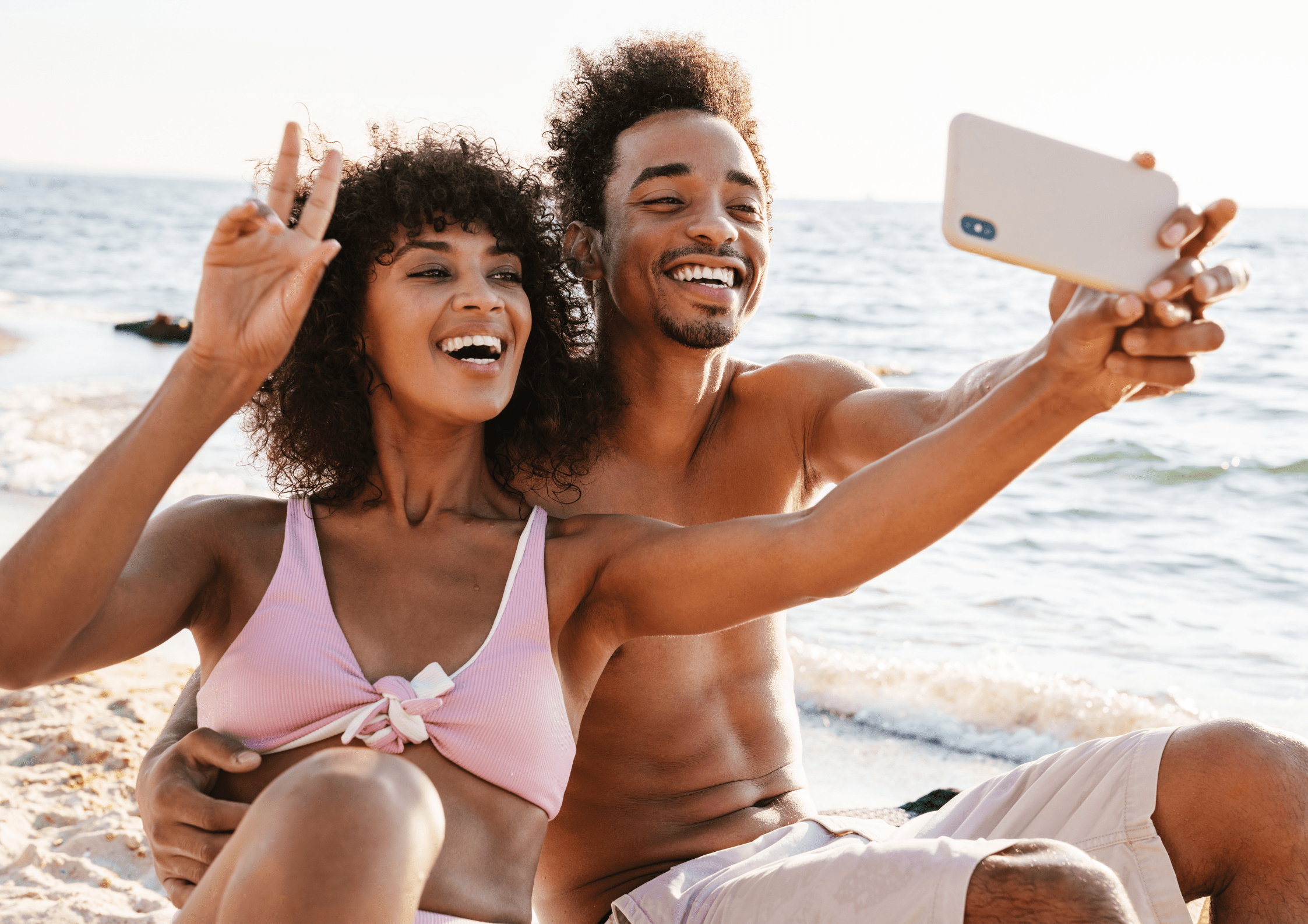 Man and woman on the beach are taking a selfie